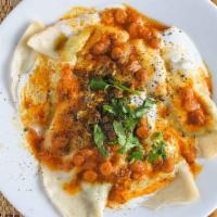 Aushak · Scallion-filled steamed dumplings topped with spicy yogurt and meat sauce, sprinkled with mi...
