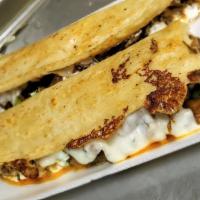 Machete · Tortilla de maíz grande hecha a mano, queso mozzarella, elección de carne, cebolla asada, ci...