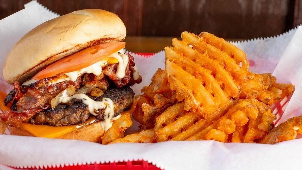 The Ol’Dog Burger · Classic burger with cheese topped with a fried egg, bacon, garlic aioli, tomato, and grilled onions. Served with waffle fries.