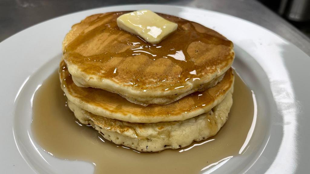 Pancake Stack · 3 pancakes garnished with whipped butter served with syrup on the side.