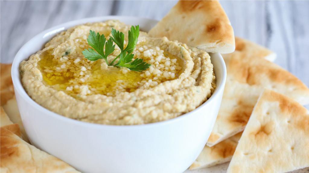 Garlic Hummus With Pita · Mashed chickpeas, garlic sauce, lemon juice, tahini sauce, special spices topped with olive oil.