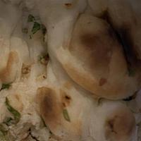 Garlic Naan · Naan touched with fresh garlic and herbs baked in tandoori oven.