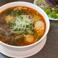 Bún Bò Huế / Spicy Beef Noodle Soup · Served spicy. Round Shanghai rice noodle, beef shank, slice Vietnamese pork ham, & pork picn...