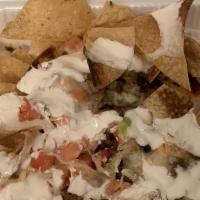 Super Nachos · Served with meat, cheese, beans, guacamole, cilantro, onions and sour cream.