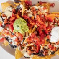 Nachos · Homemade tortilla chips topped with black beans , cheese , jalapenos , sour cream , guacamol...