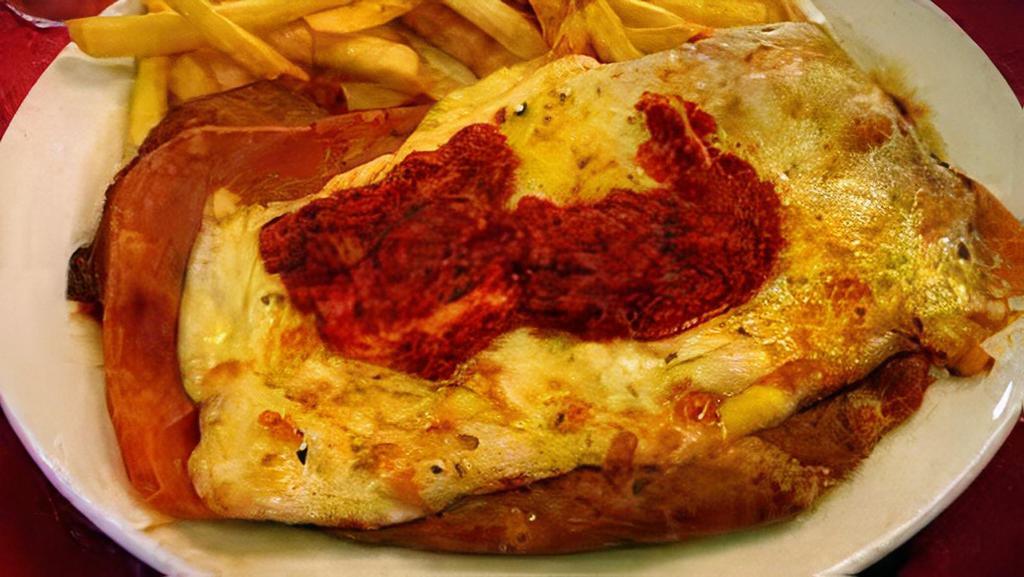 Milanesa Napolitana · Lightly fried breaded beef, topped with slice of ham, tomato sauce and melted mozzarella cheese. Served with a side of French fries.