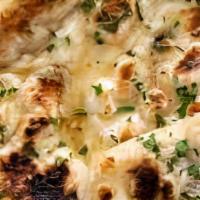 Garlic Naan · Leavened bread, topped with fresh garlic and cilantros cooked in a tandoor oven.