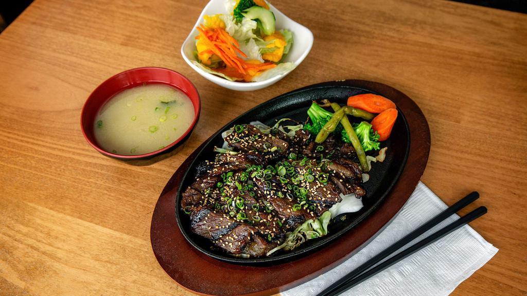 Kalbi · Grilled marinated beef short ribs, steamed vegetables, sesame see. Served with small mio salad.
