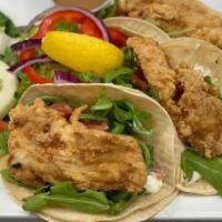 Fish Tacos · FRESH FRIED FISH SERVED WITH RADISHES, ARUGULA, TOMATO, AND TARTAR SAUCE