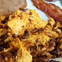 Huevos Con Chorizo · Two large eggs scrambled with Mexican sausage. With Refried Beans