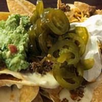 Beef Fajita Nachos · Crispy tortilla chips with refried beans, cheese, fajita meat, and jalapenos. Served with gu...
