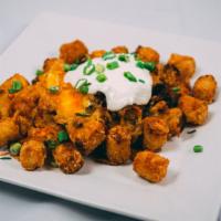 Loaded Tater Tots · Tater Tots loaded with cheddar cheese and bacon.  Served with a side of sour cream.