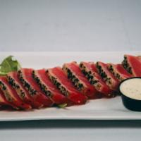 Sesame Encrusted Tuna · Ahi tuna seared rare and encrusted with white and black sesame seeds.  Served with a side of...