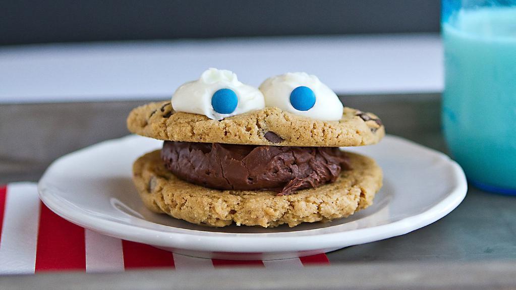 Cookie Monster · Scoop of vanilla or fudge frosting sandwiched between two chocolate chip cookies. Monster is completed with a dip in sprinkles and frosting eyes.