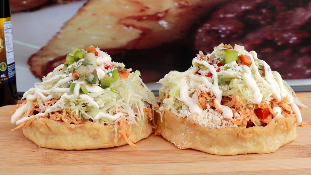 Sopes (2) · Corn dough topped with refried beans and choice of meat, cabbage, pico de gallo, pickled onion, and cheese.