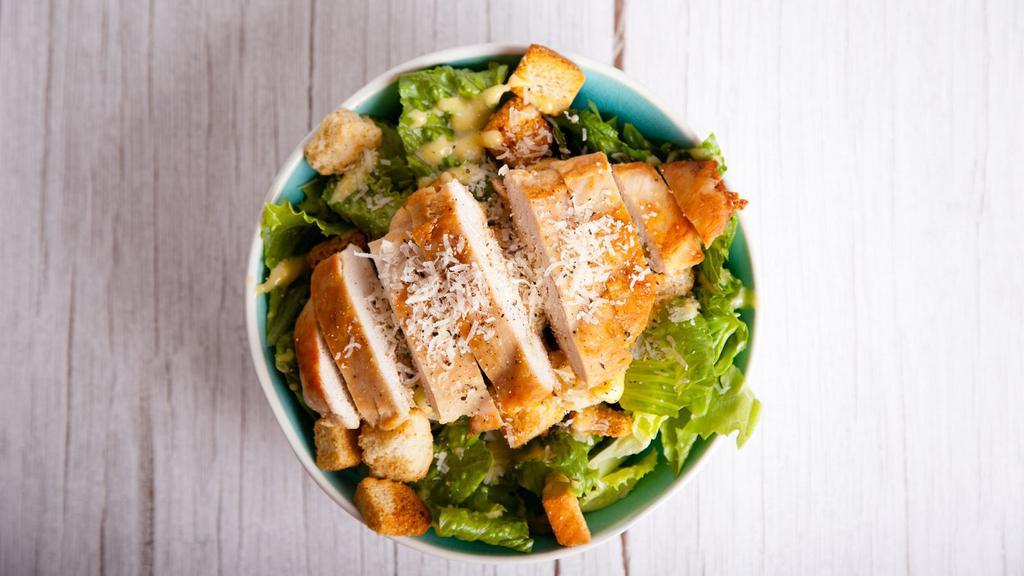 Grilled Chicken Caesar Salad · Tender grilled chicken with toasted, garlic croutons, parmesan cheese and grape tomatoes on a bed of crisp romaine lettuce with creamy Caesar dressing.