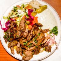 Gyro Platter · Sliced lamb and gyro meat served on a bed of rice with salad, tzatziki sauce, and fresh pita.