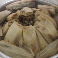Tamales · Corn tamales with chicken wrapped in cork husks or plantain leafs.