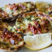 Oysters Rockefeller · Fresh shucked local oysters topped with bacon, baby spinach, and Parmesan in a Sambuca cream...