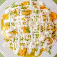 Chilaquiles · The chilaquiles come with refried pinto beans on the bottom, chips, eggs, onions, cilantro, ...