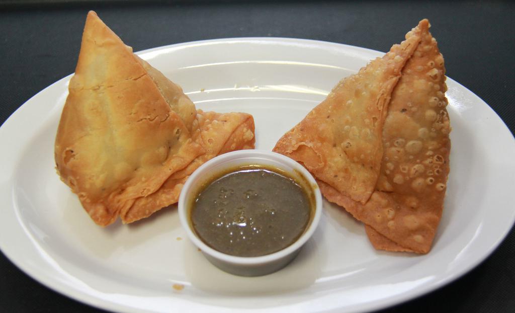 Vegetable Samosas (V) (2Pc) · Golden fried, filled with potatoes, and green peas, flaky pastry served with our cilantro and tamarind chutney.