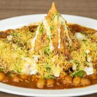 Samosa Chaat · Fried pastry filled with spiced potatoes and peas topped with garbanzo beans, raita, and swe...
