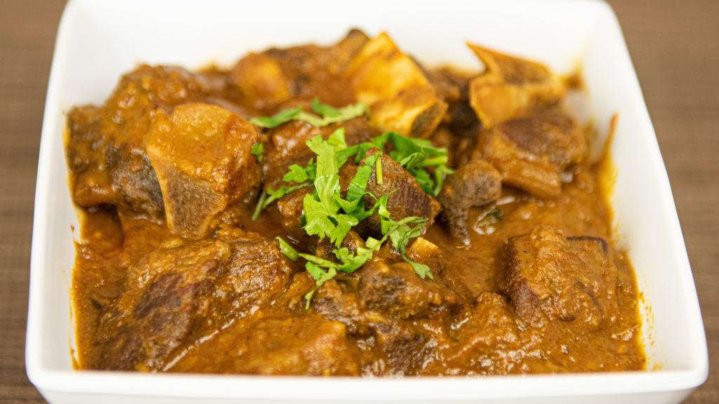 Goat Curry (G) · Halal Goat meat with bones in, cooked with ginger, garlic, onions, and fine blend of dry spices and herbs.