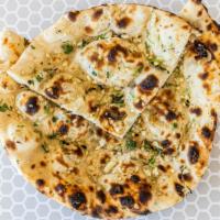 Naan Plain Or Garlic · Soft clay oven baked flatbread.