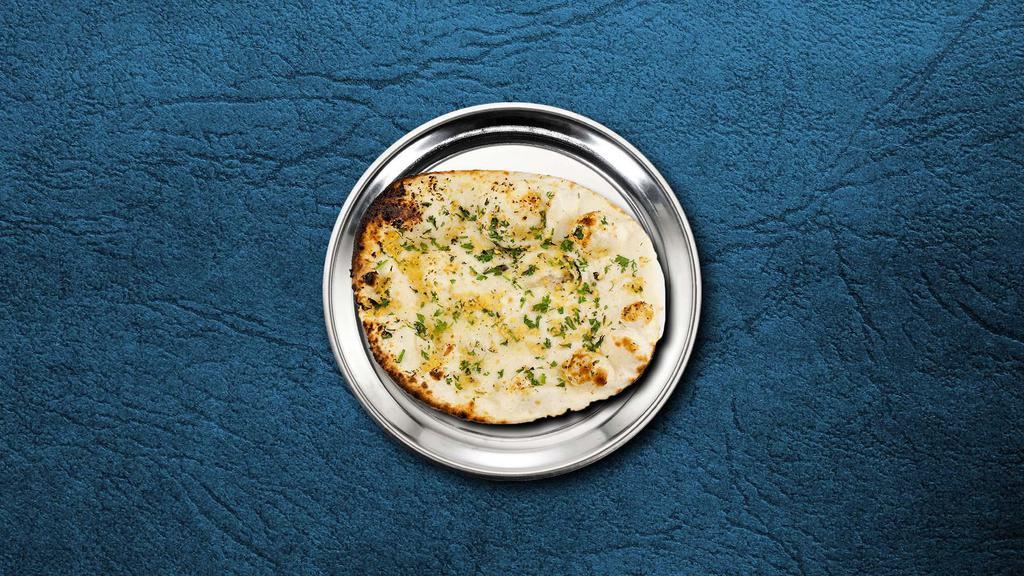 Garlic Naan Bread · A refined flour leavened flatbread pressed with minced garlic and baked over an Indian clay oven.