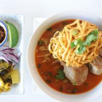 Khao Soi · Northern style red curry with egg noodles, chicken drumsticks, and topped with crispy egg no...