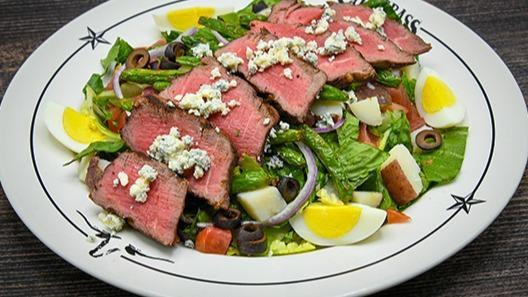 Steak Salad · Center-cut top sirloin, crisp romaine, red potatoes, eggs, green beans, black olives, onions, tomatoes, bleu cheese, balsamic vinaigrette.