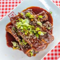 Asian Sticky Ribs · Slow braised pork ribs, green onions, sesame seeds and chilies.