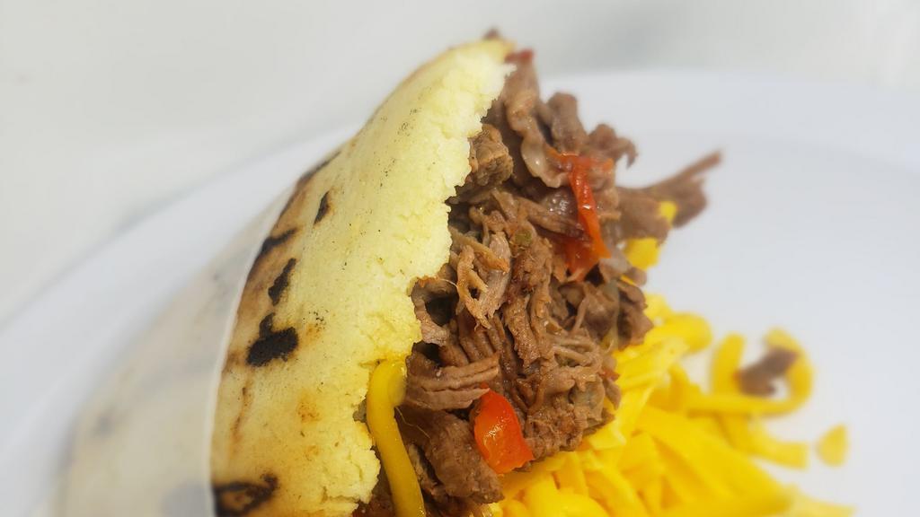 Carne Mechada · Shredded beef in juicy onions and peppers sauce.