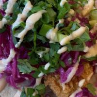 Baja Fish Taco · Cabbage, scallions, cilantro, salsa verde, and chipotle, on flour tortilla.