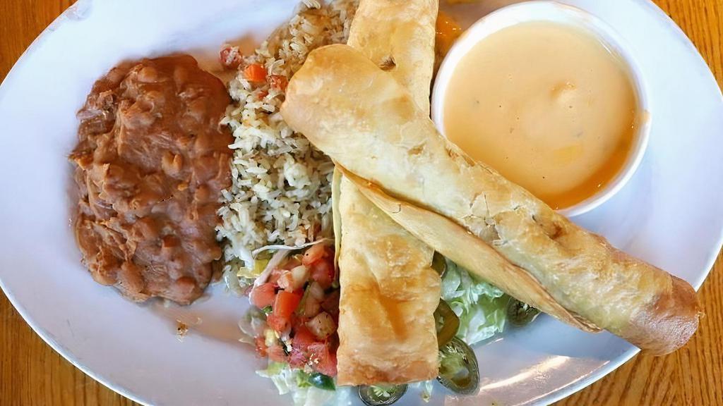 Flautas · Crispy flour tortillas, rolled with seasoned ground beef with pico de gallo and Monterey Jack and cheddar cheeses. Served with chile con queso, pickled jalapeño and pico de gallo. Served with green chile rice & refried beans (or substitute mashed black beans.)