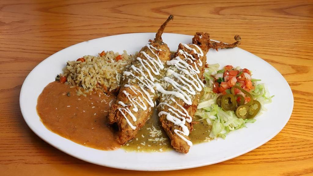 Rellenos Chicken · Two fire-roasted, stuffed, breaded and fried Anaheim peppers with hand-pulled chicken and Monterey Jack cheese with your choice of sauce: chile verde or green chile deluxe. Topped with queso fresco and drizzled with sour cream. Served with pico de gallo and pickled jalapeño. Served with green chile rice & refried beans (or substitute mashed black beans.)