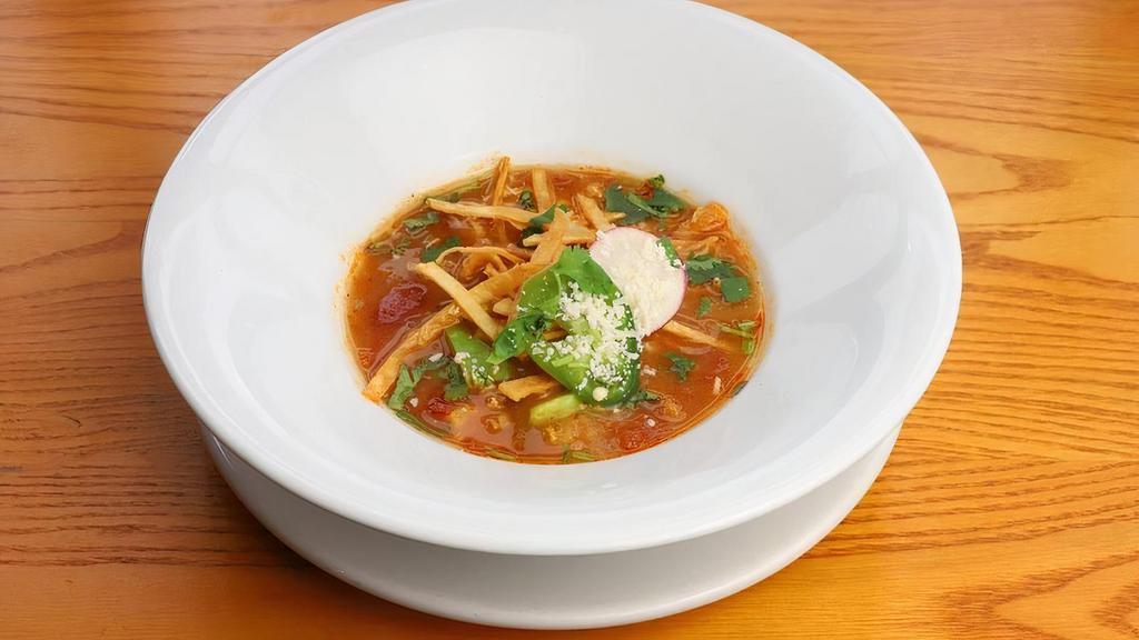 Soup Tortilla Cup [Gs] · Spiced chicken broth, hand-pulled chicken, queso fresco, red radish, avocado, cilantro, hominy, fresh jalapeño and tortilla strips.