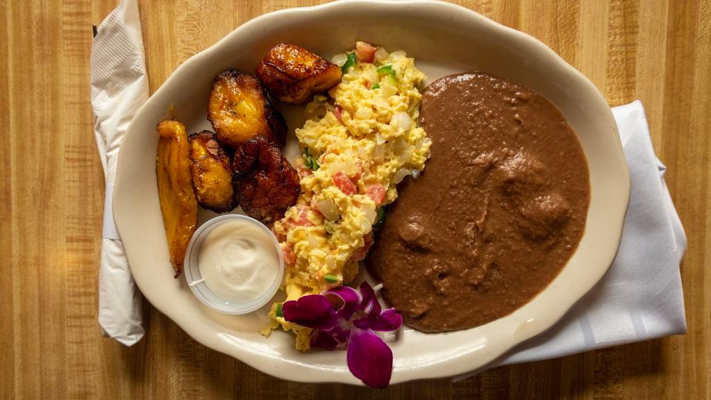 Mexican Style · Consuming raw or undercooked meats, poultry, seafood, shellfish, or egg may increase your risk of foodborne illness, especially if you have certain medical conditions.  

Two scrambled eggs with jalapeños, onions, tomatoes, served with refried beans, plantains and tortillas.
