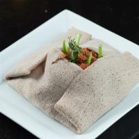 Quanta Fir-Fir · Shredded injera stir-fried with berbere, jerky beef and kibbe. It served with injera or bread.