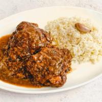 Pollo Guisado Con Arroz · Chicken, caramelized onions and sherry wine stew served with garlic sautéed rice