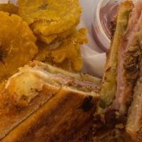 Traditional Cubano · Authentic Pan de Agua, Pork slow roasted in Mojo, Ham, Swiss Cheese, Pickles, and Yellow Mus...