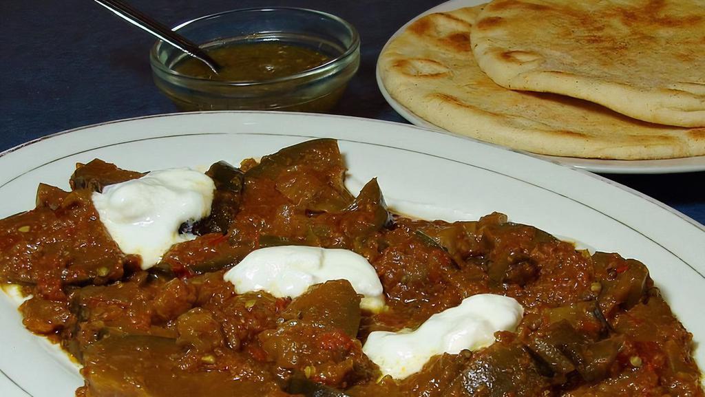 Eggplant Bouranee · Cooked in spiced tomato sauce, with yogurt and roti.