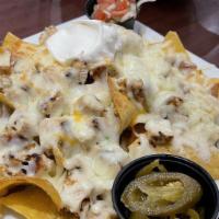 Nachos · Tortilla chips topped with melted cheese and refried beans. Served with pico de gallo and so...