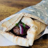 Lula Kebab Wrap · Marinated ground beef kebab wrapped in pita with onions, & herbs