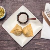 Chaat Samosa · A famous street food from Nepal made with scrambled samosa topped with mint, tamarind, veggi...