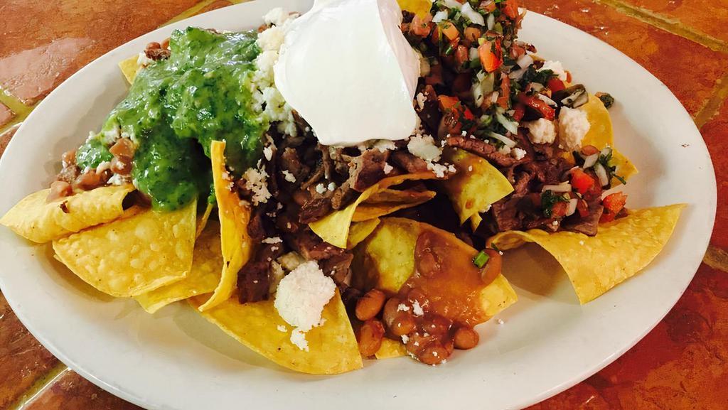 Azteca Nachos · Loaded nachos topped with choice of meat chicken, steak, or beef, refried beans, lettuce, fresh pico de gallo, pickled radish, jalapeños, sour cream and cheese.