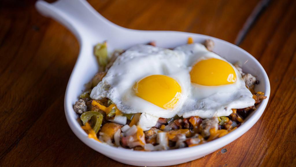 Meat Lovers Skillet · Two eggs any style with ham, bacon, sausage, onions & peppers. Topped with melted monterrey jack & cheddar cheese. Served with country potatoes & toast.