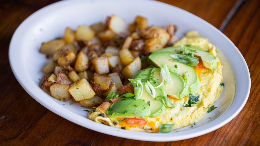 Blue Spring Omelette · Blue cheese crumbles, cheddar cheese, spinach & mushrooms. Topped with avocado, tomato and green onions.