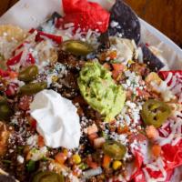 Georgie'S Deluxe Nachos · Choice of ground beef, pulled pork or chicken. Topped with pico de gallo, jalapeños, corn, b...