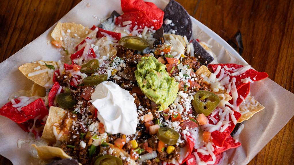 Georgie'S Deluxe Nachos · Choice of ground beef, pulled pork or chicken. Topped with pico de gallo, jalapeños, corn, black beans, queso fresco, sour cream & guacamole.